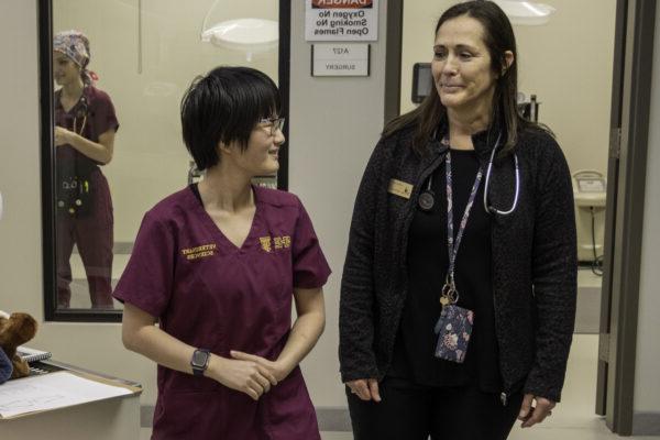 a woman standing next to a woman wearing scrubs, health sciences admissions